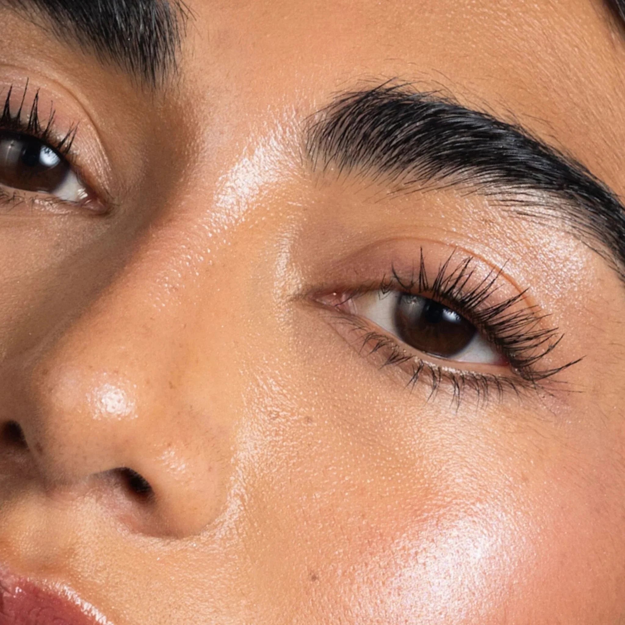 Close-up of a person's eye with long, thick eyelashes.